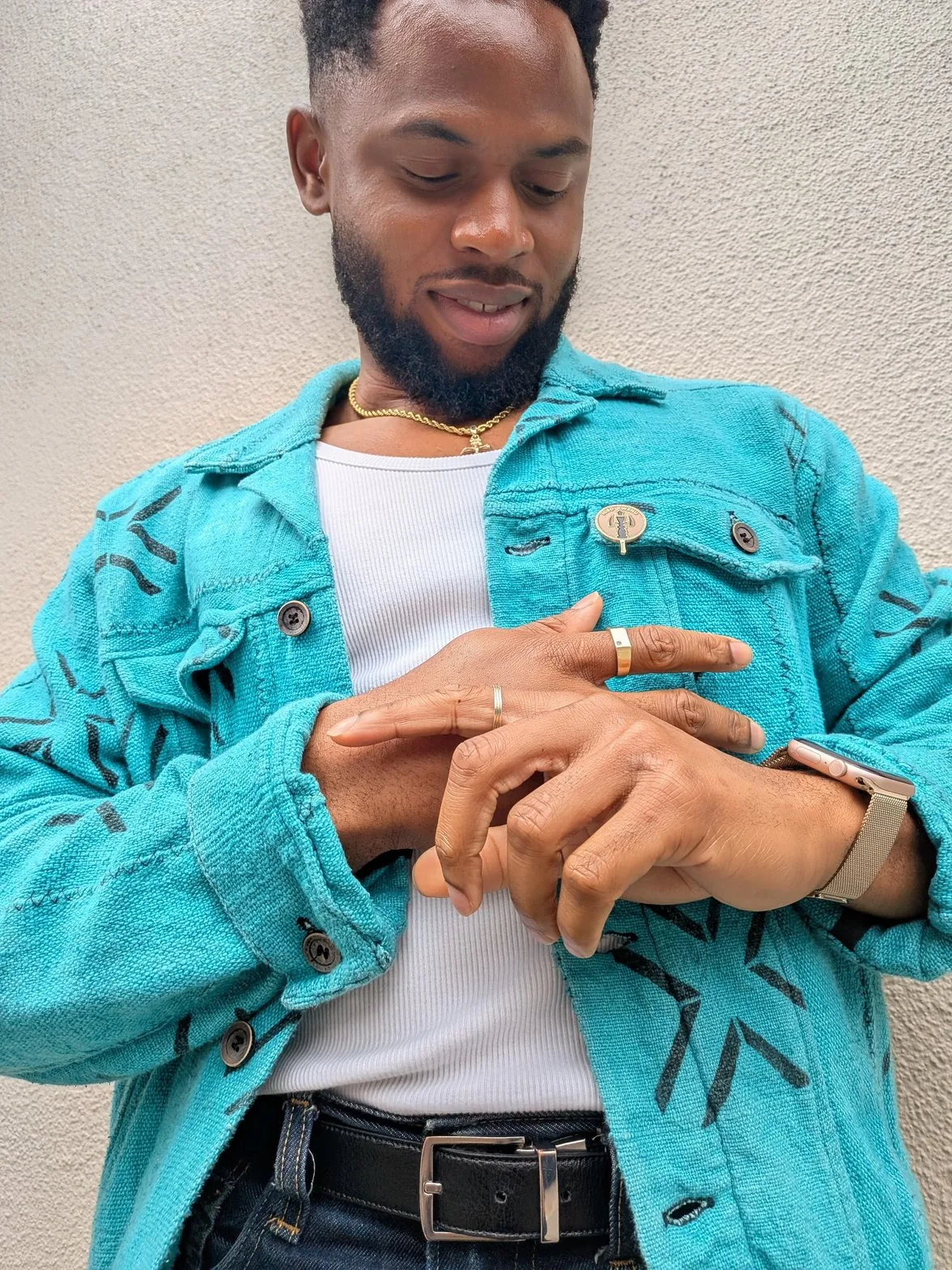 Chielo's hands showing gold rings and mud cloth jacket detail