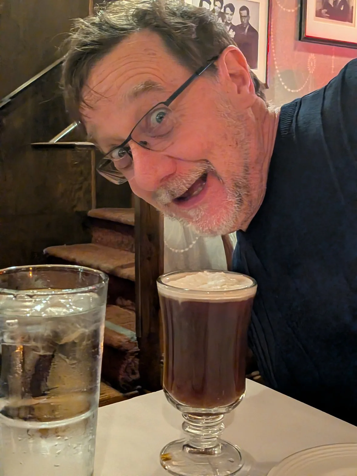 Bob leaning in with wide eyes next to an Irish coffee