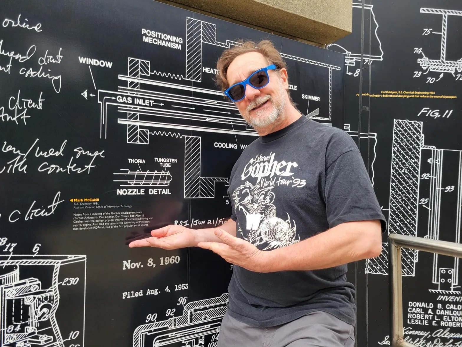Bob in his Internet Gopher World Tour tee gesturing at a schematic wall
