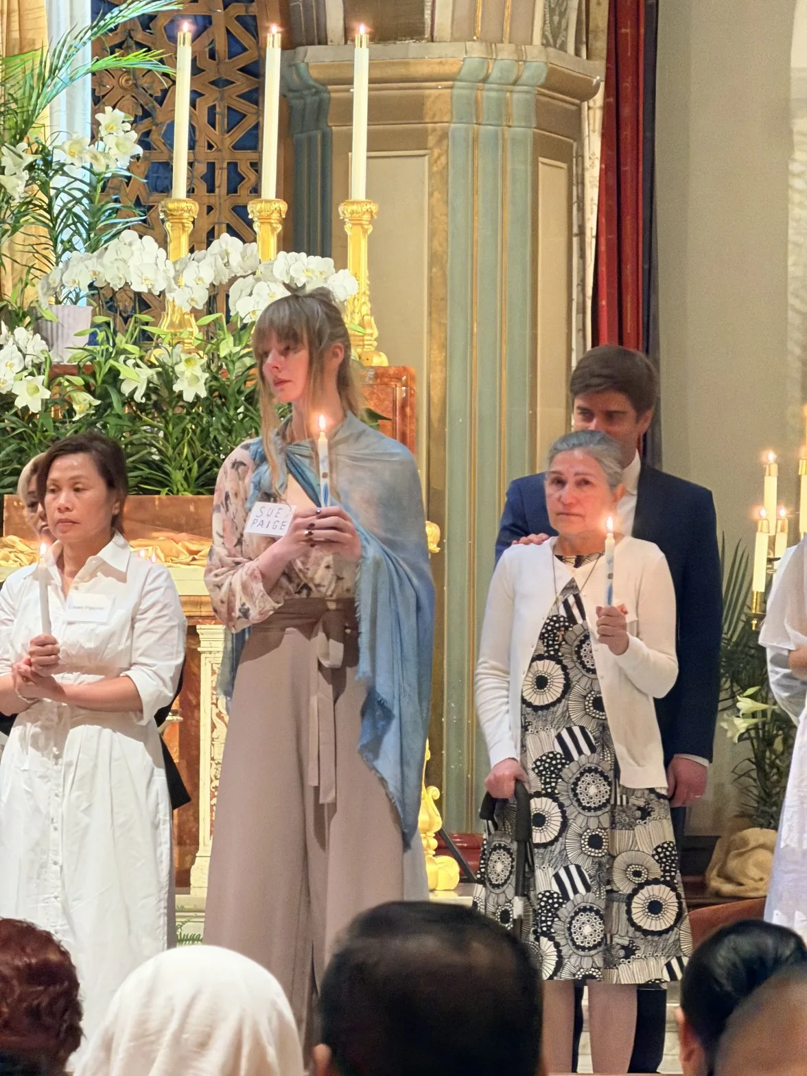Sue holding a candle in the cathedral wearing her Monet shawl